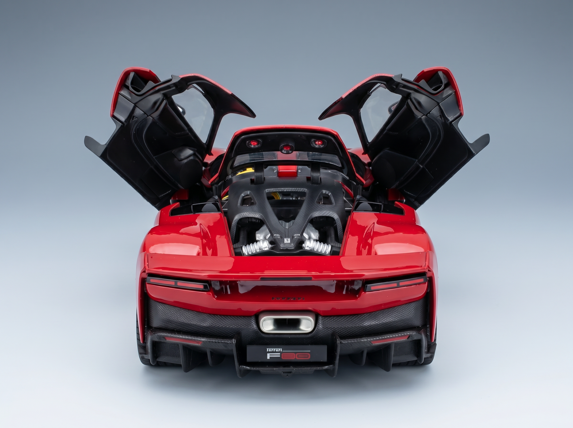 Rotes Ferrari F80-Modellauto mit geöffneten Türen, detailgetreuem Motor und Heck aus Carbonfaser – Vroomi
