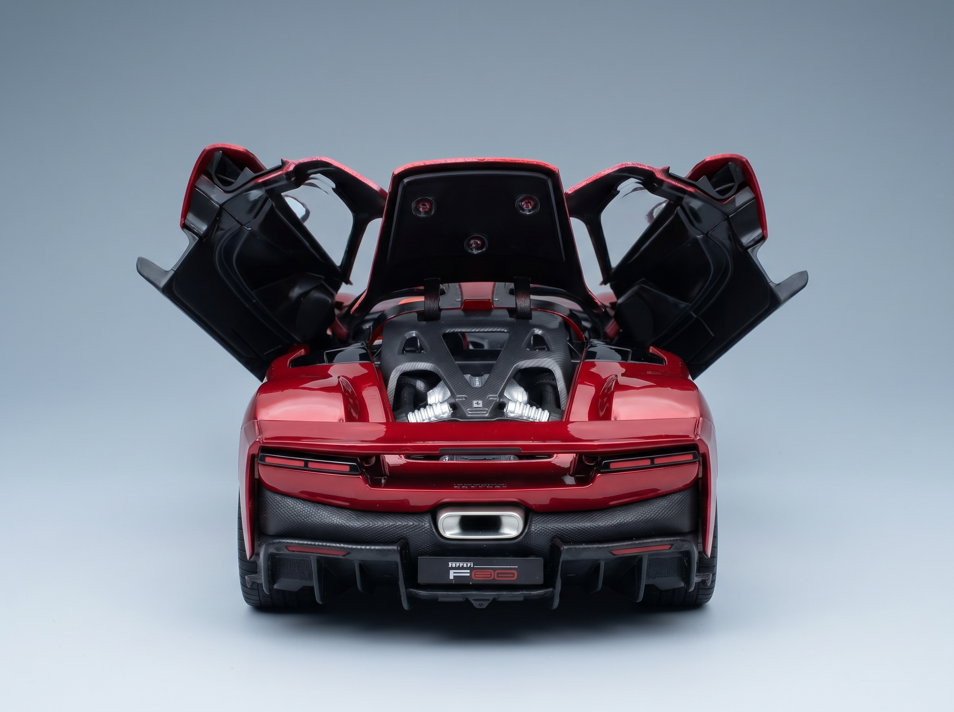 Red Ferrari F80 scale model car with open doors and engine bay, showcased by Vroomi