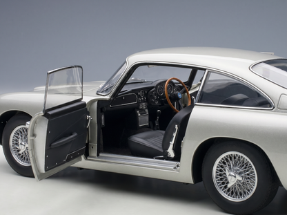 Silver scale model car with open door, showcasing interior details, available at Vroomi