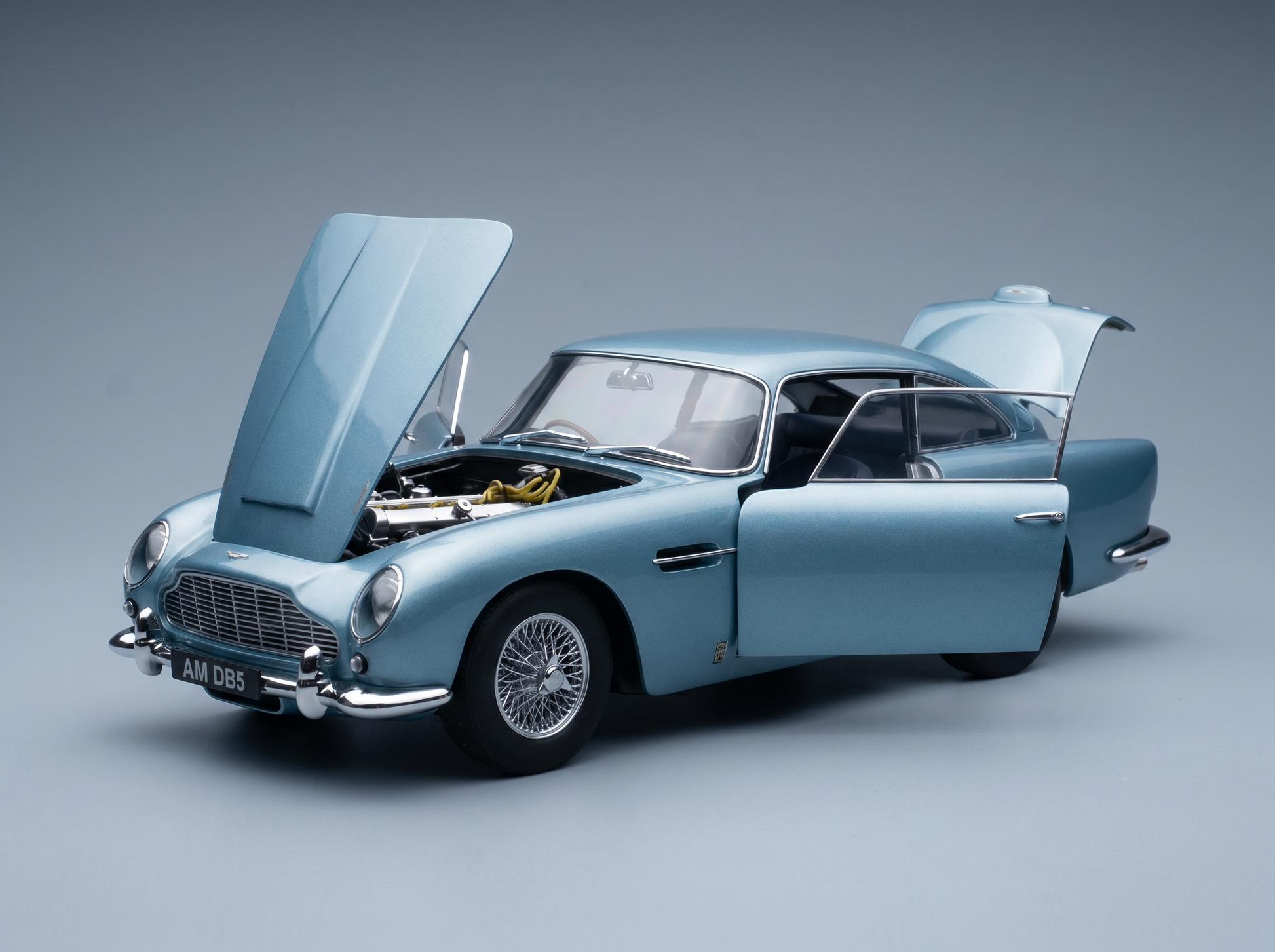 Light blue Aston Martin DB5 scale model car with open hood and doors, detailed engine, from Vroomi