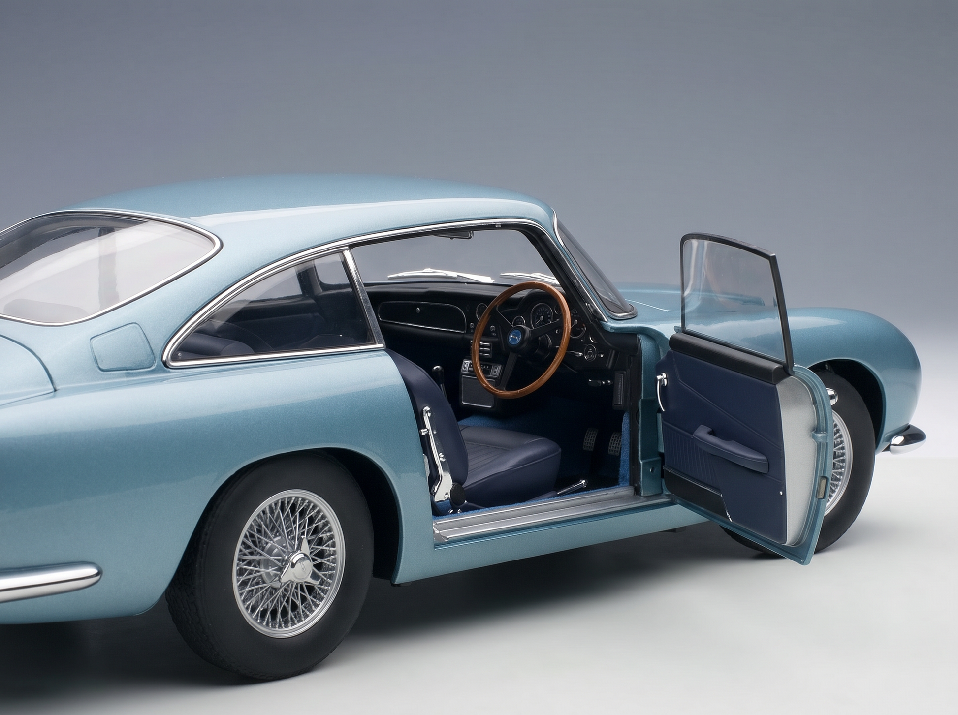 Light blue scale model car with open door, detailed interior, wire wheels — Vroomi collector's replica