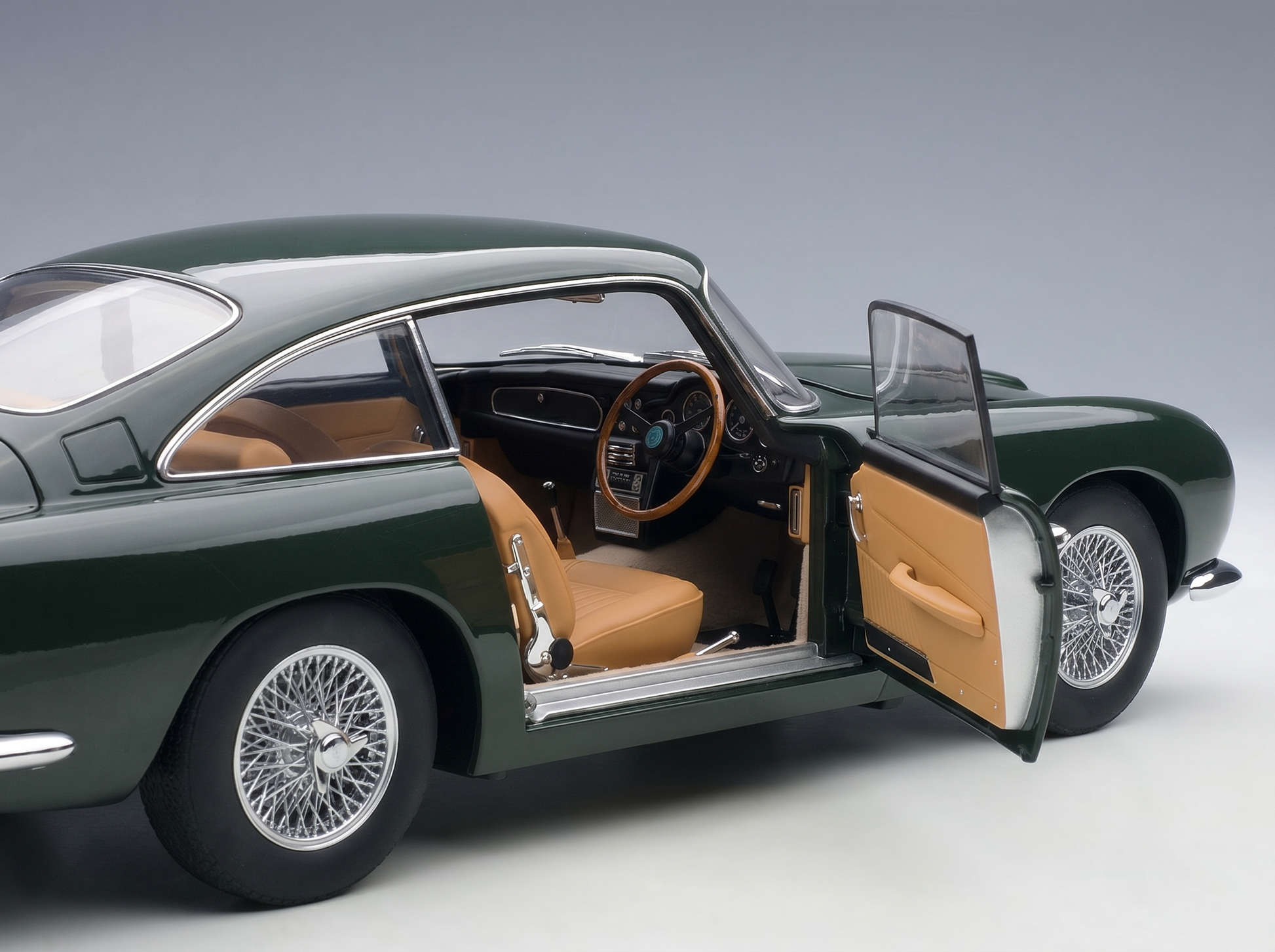 Green scale model car with tan interior and open door, showcasing detailed cockpit — Vroomi