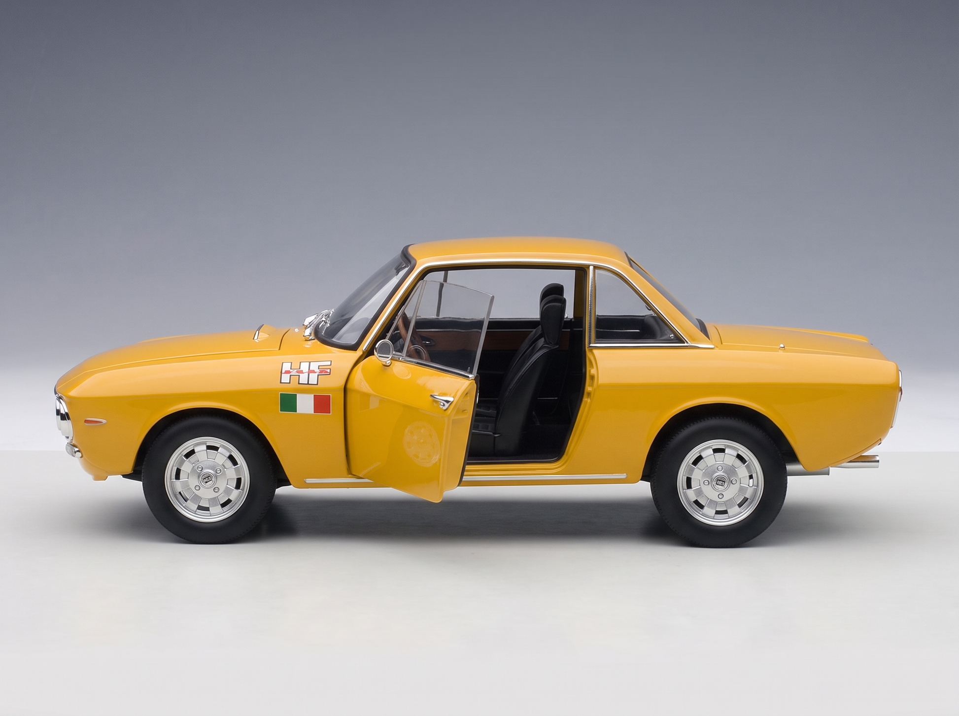 Modèle réduit de voiture jaune avec porte ouverte, logo HF et drapeau italien, chez Vroomi