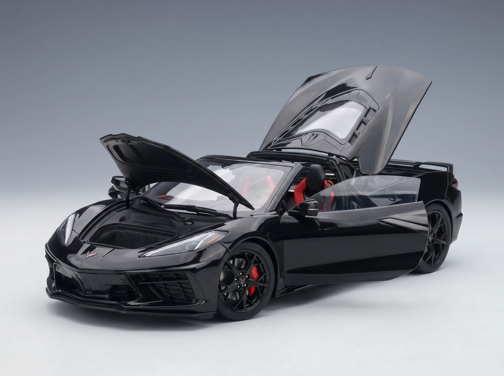 Black scale model car with open doors and hood, showcasing red interior, from Vroomi