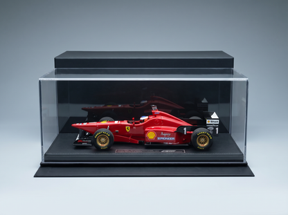 Red Ferrari F1 scale model car in display case, featuring Shell and Goodyear logos, showcased by Vroomi