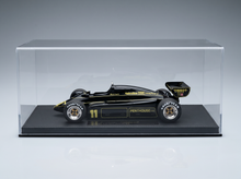 Schwarz-goldenes Modellauto mit „Vroomi“-Logo, ausgestellt in einer durchsichtigen Vitrine.