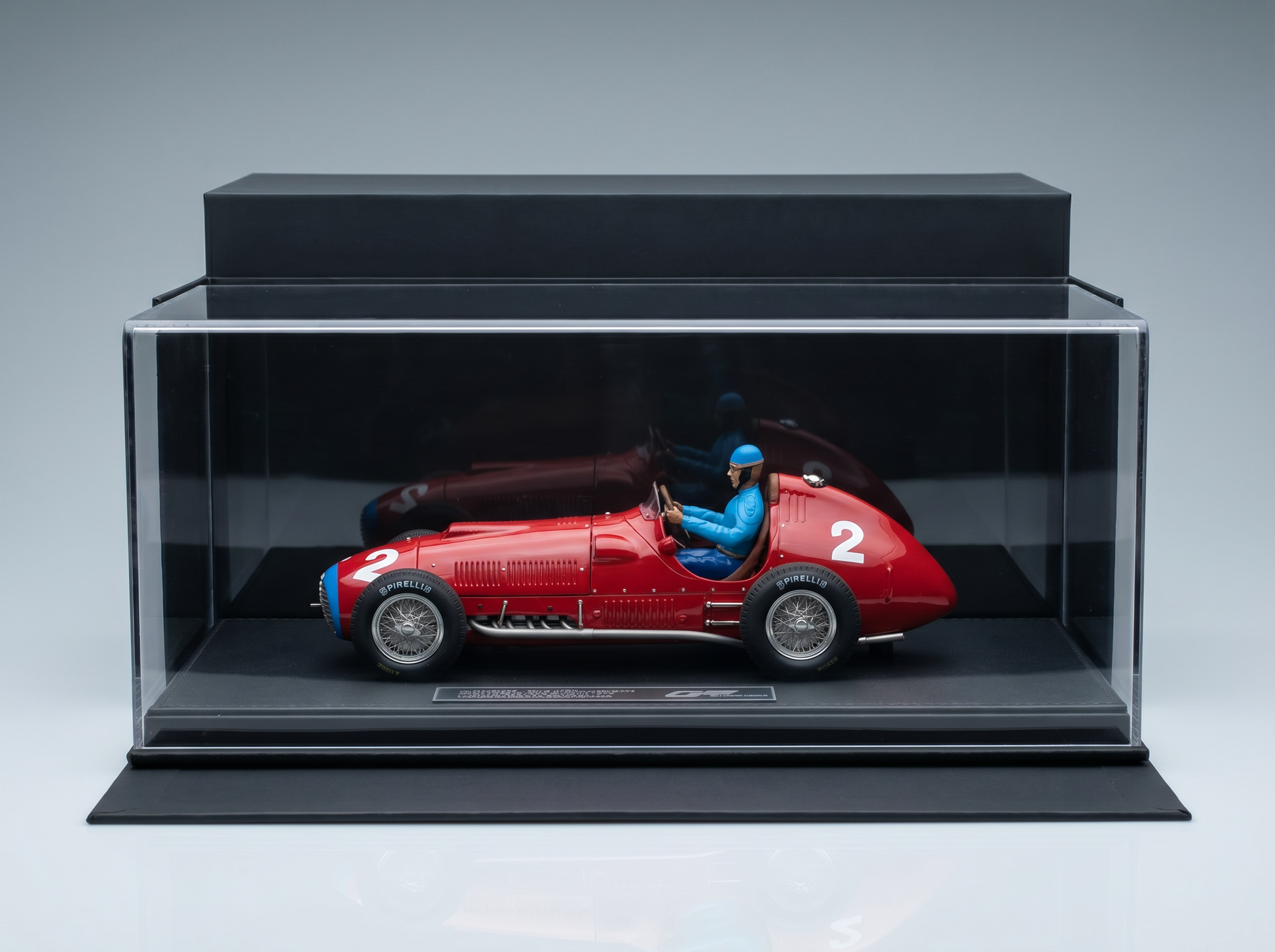 Red scale model car with driver, displayed in clear case — Vroomi collector's replica