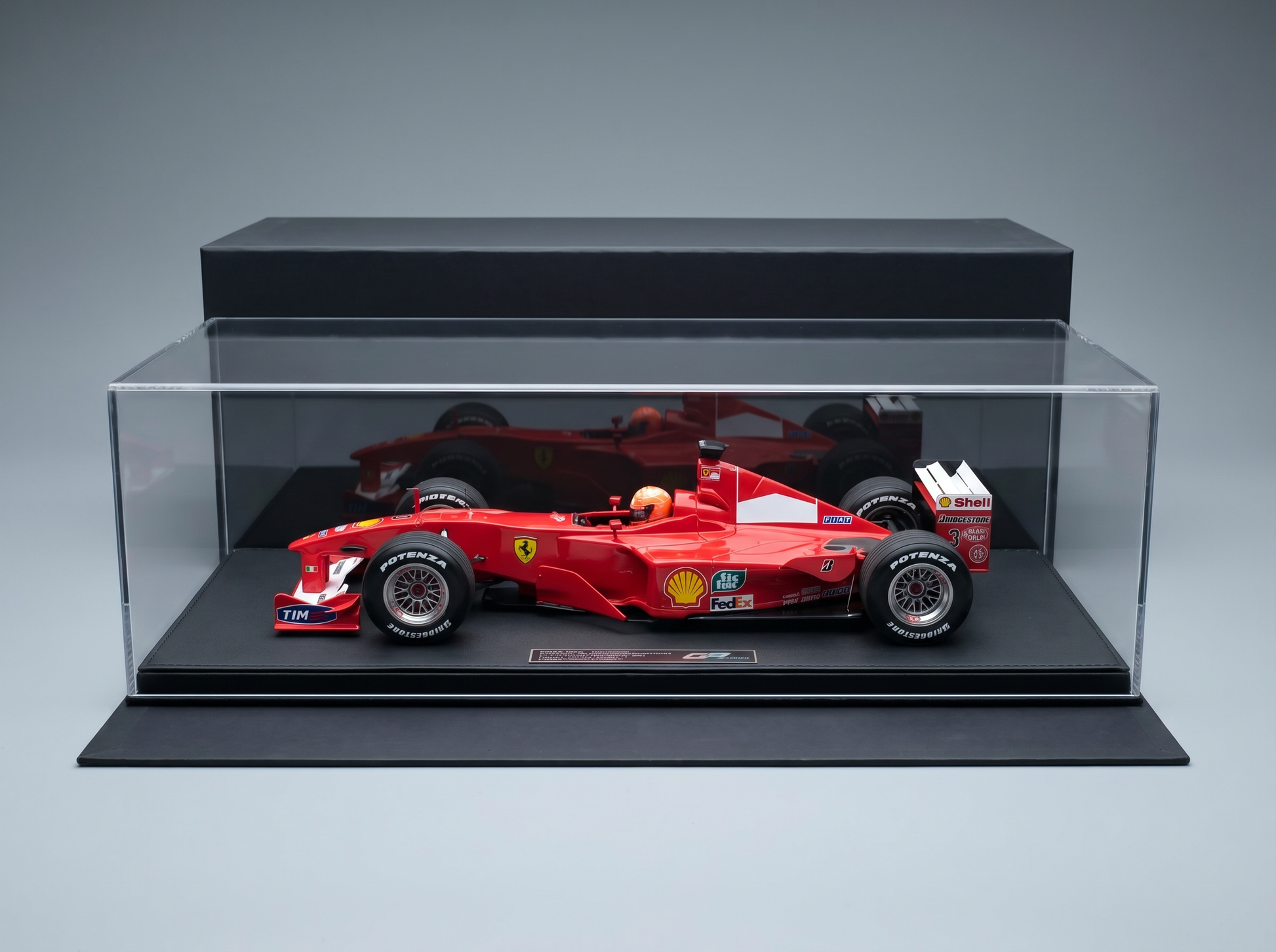 Maquette de voiture de F1 Ferrari rouge dans une vitrine, arborant les marques Shell et Potenza, sélectionnée par Vroomi