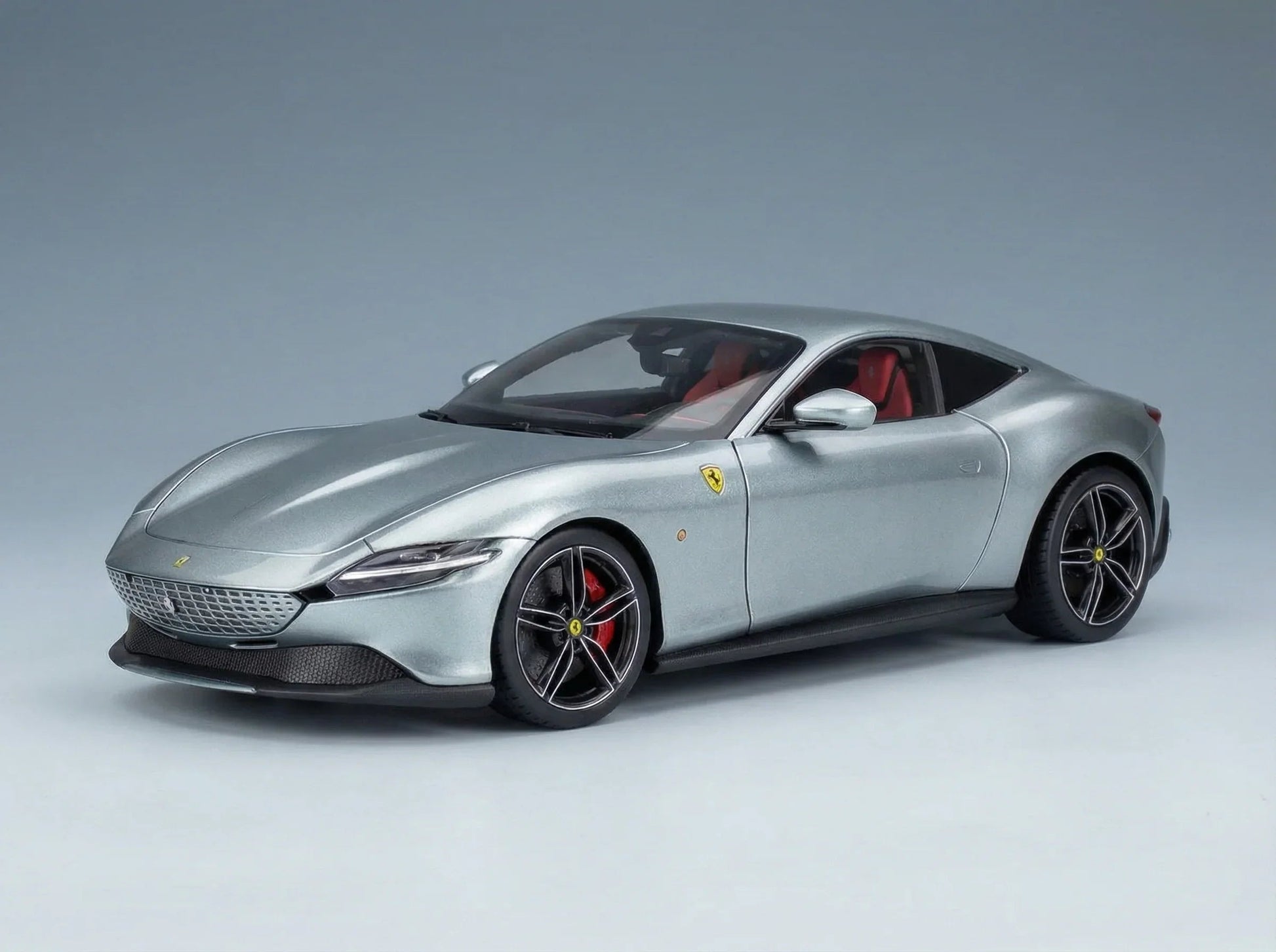 Maqueta de un Ferrari plateado con interior rojo, presentada por Vroomi para coleccionistas.