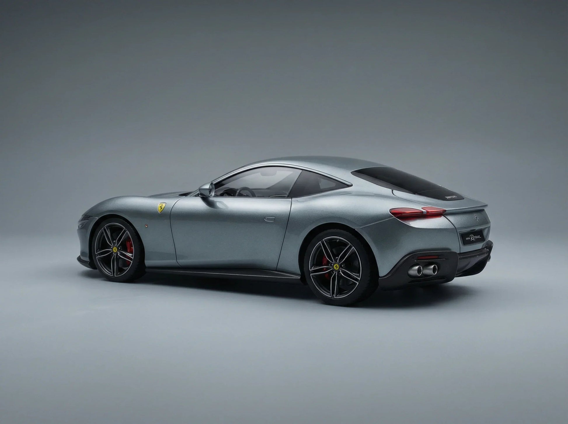 Maqueta a escala de un Ferrari Roma plateado con pinzas de freno rojas, presentada por Vroomi para coleccionistas