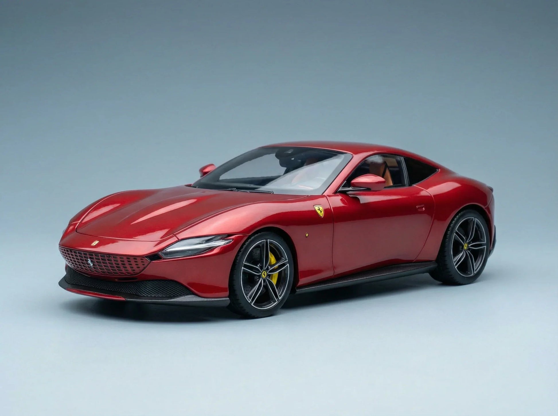 Rood Ferrari-schaalmodel van Vroomi, met een strak ontwerp en gedetailleerde wielen op een grijze achtergrond