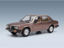 Bruin schaalmodel van een auto met een beige interieur, gepresenteerd door Vroomi voor verzamelaars.