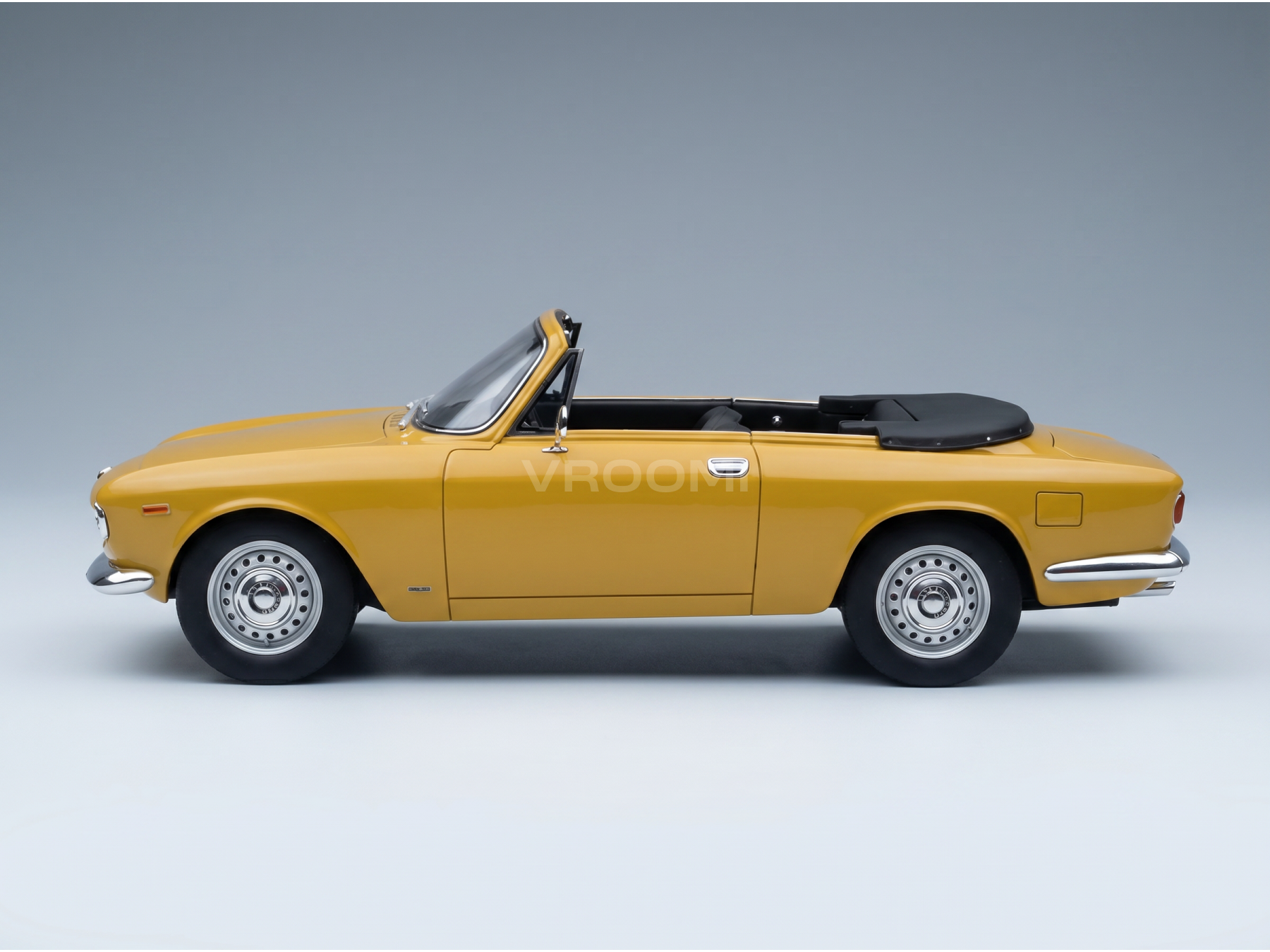 Maquette de voiture décapotable jaune avec capote noire, présentée par Vroomi pour les collectionneurs