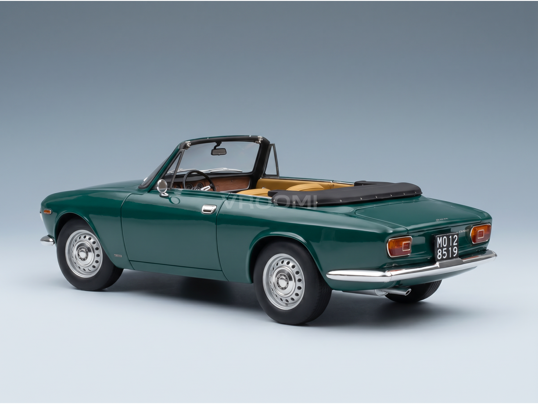 Maquette de voiture décapotable verte avec un intérieur beige, présentée par Vroomi pour les collectionneurs