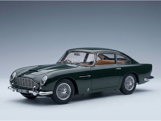 Maqueta a escala de un Aston Martin DB5 verde con llantas de radios, presentada por Vroomi para coleccionistas.