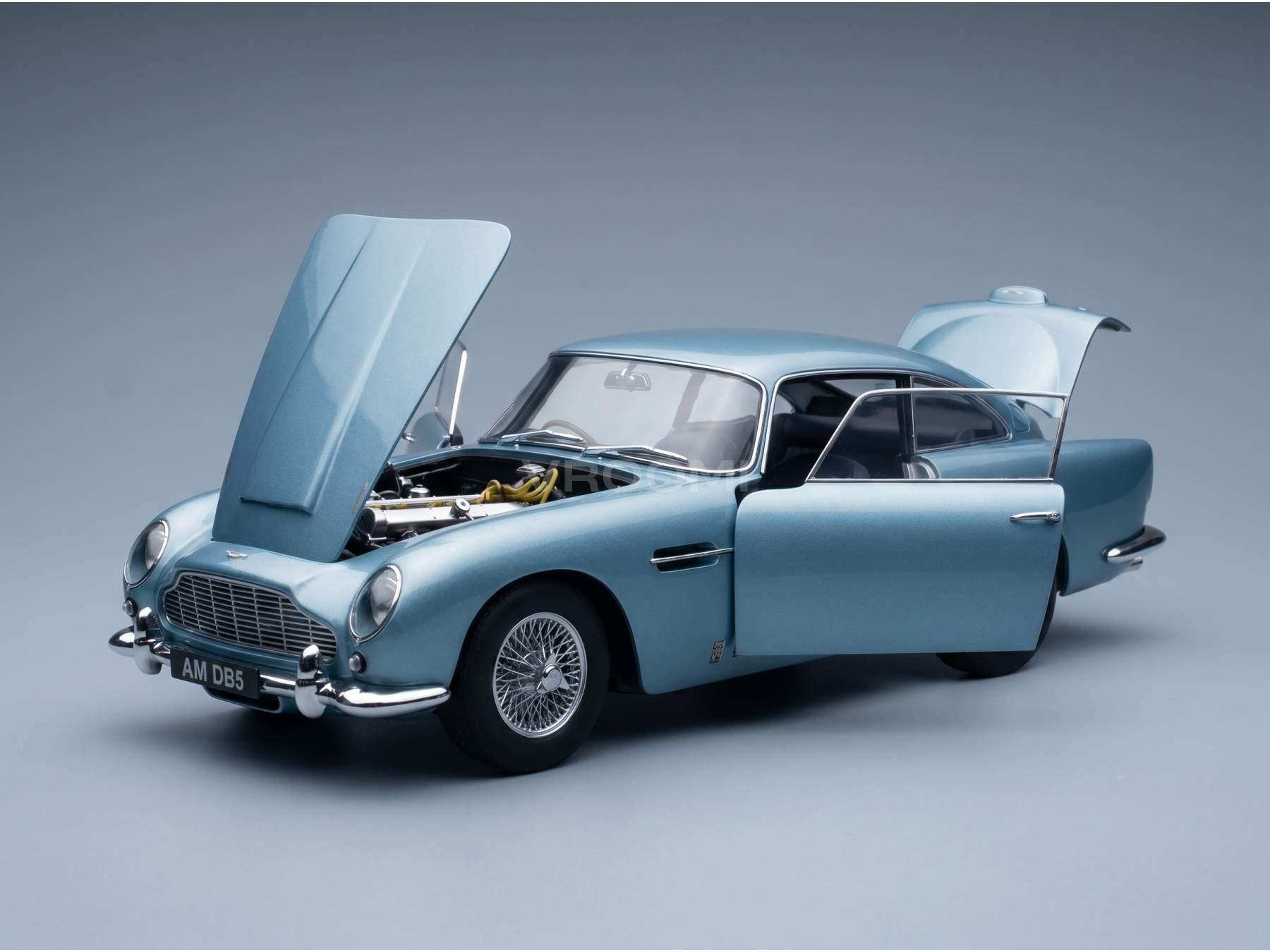 Maqueta de coche Aston Martin DB5 de color azul claro, con el capó y las puertas abiertos y un motor muy detallado, de Vroomi