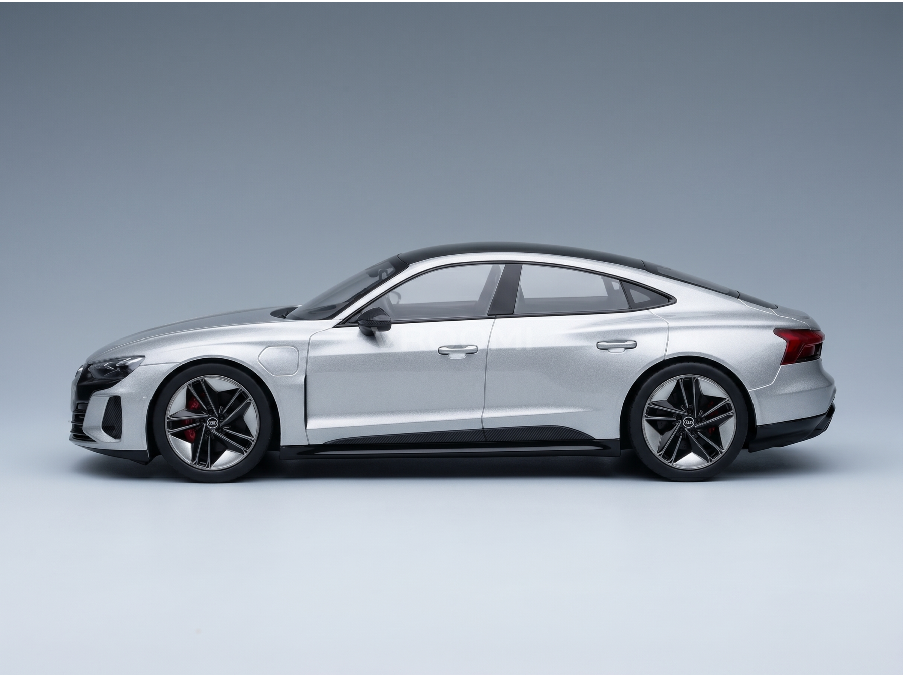 Maqueta de coche Audi plateada con llantas negras, expuesta en Vroomi para coleccionistas y aficionados.