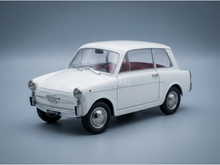 Coche en miniatura vintage de color blanco con interior rojo, presentado por Vroomi para coleccionistas