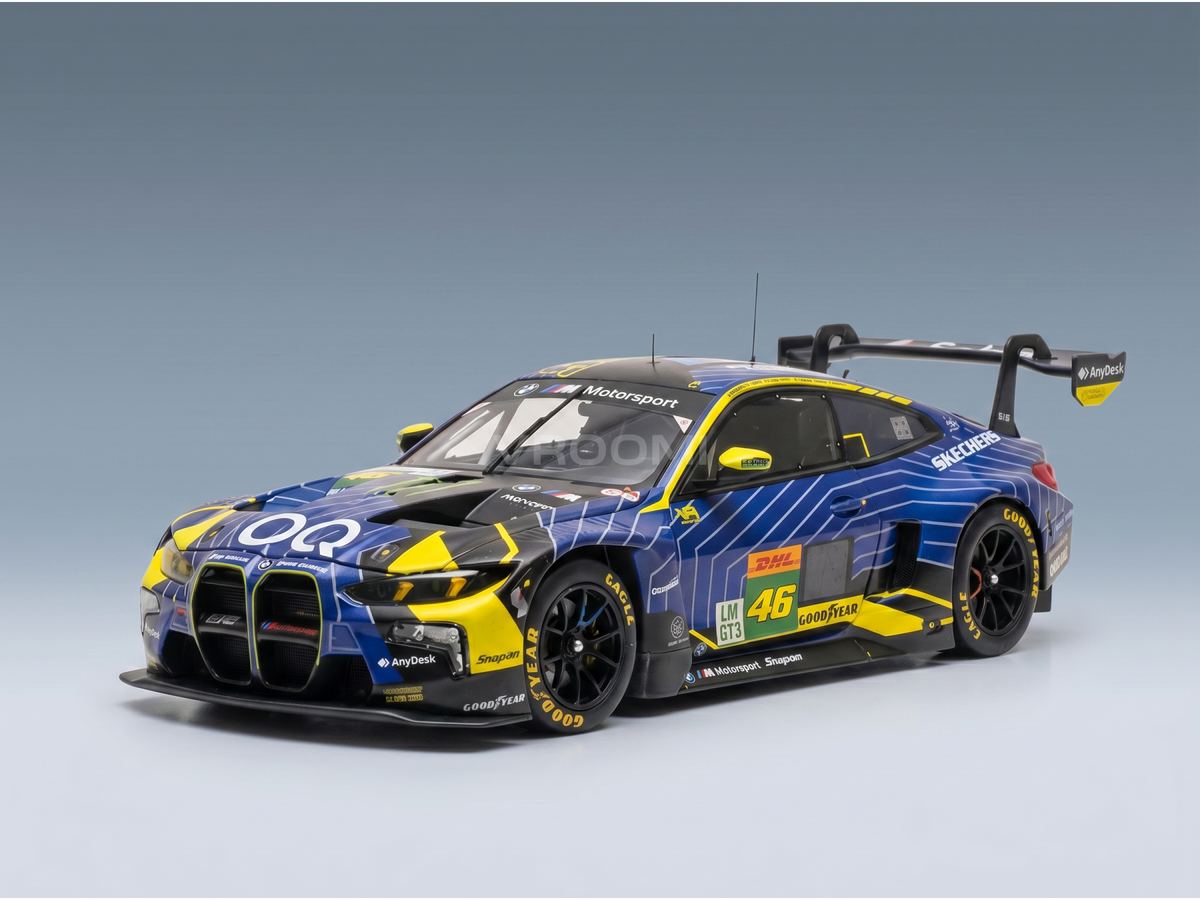 Blue and yellow BMW M4 GT3 scale model car with racing decals, displayed by Vroomi for collectors.