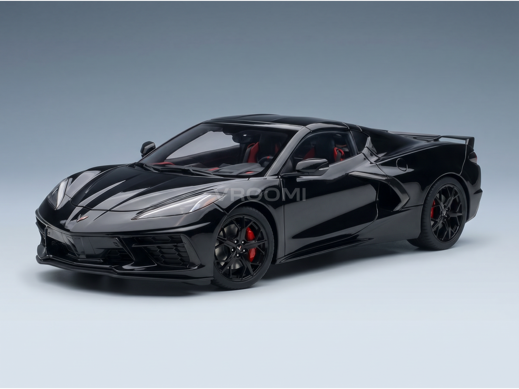 Zwart schaalmodel van een Corvette met rode accenten, gepresenteerd door Vroomi voor verzamelaars.