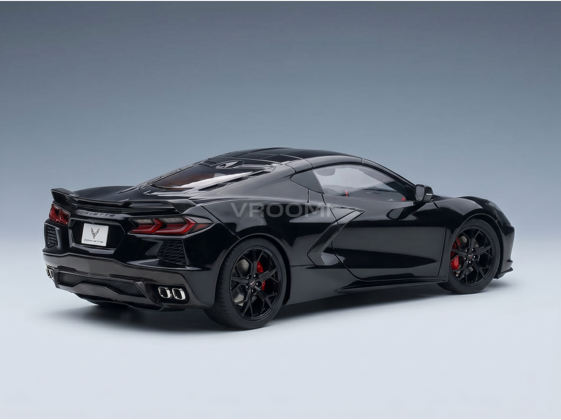 Zwart schaalmodel van een Corvette met rode remklauwen, gepresenteerd door Vroomi voor verzamelaars.