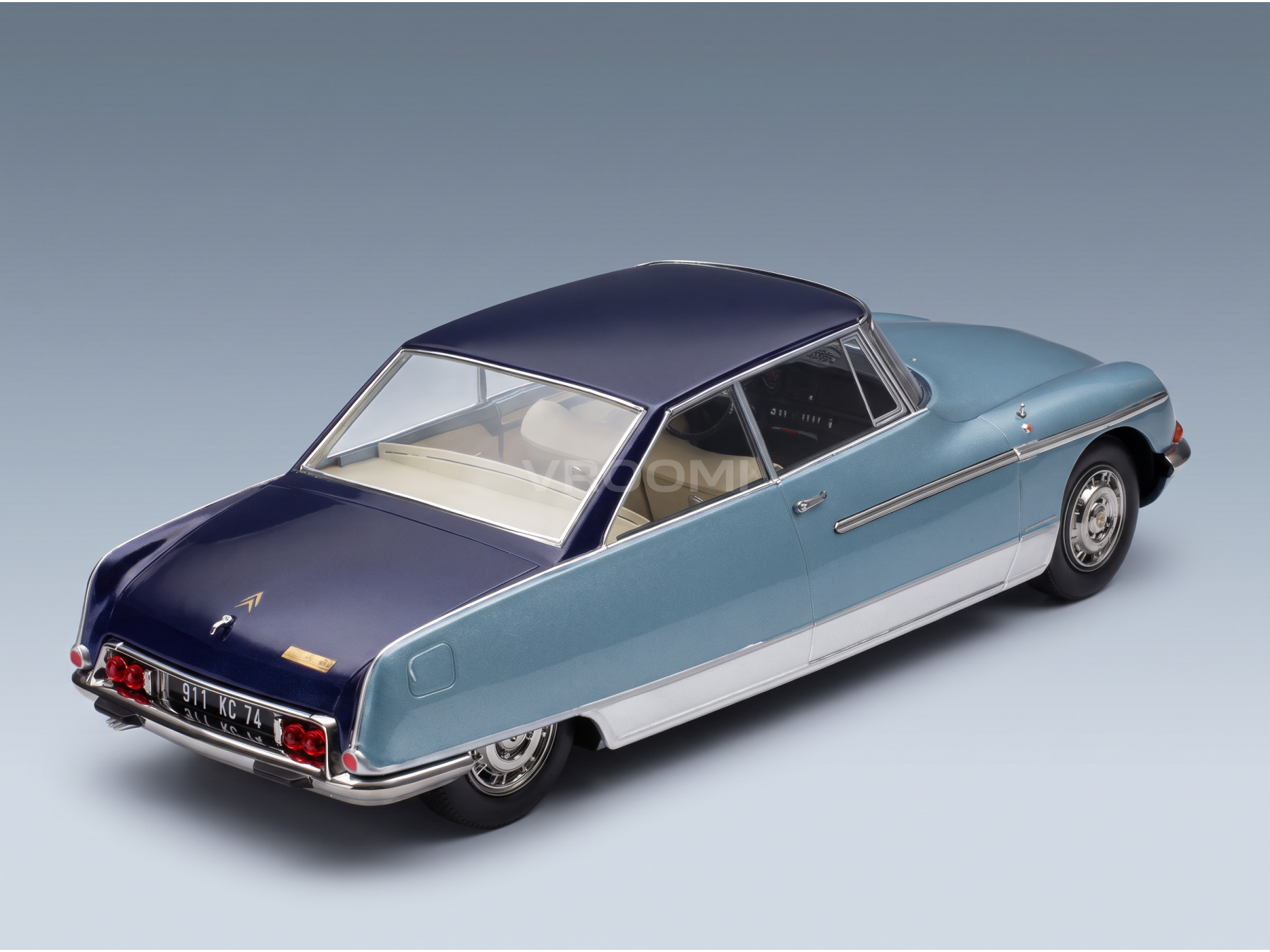 Vroomi-schaalmodelauto: klassieke tweekleurige blauwe sedan met chromen details en een crèmekleurig interieur