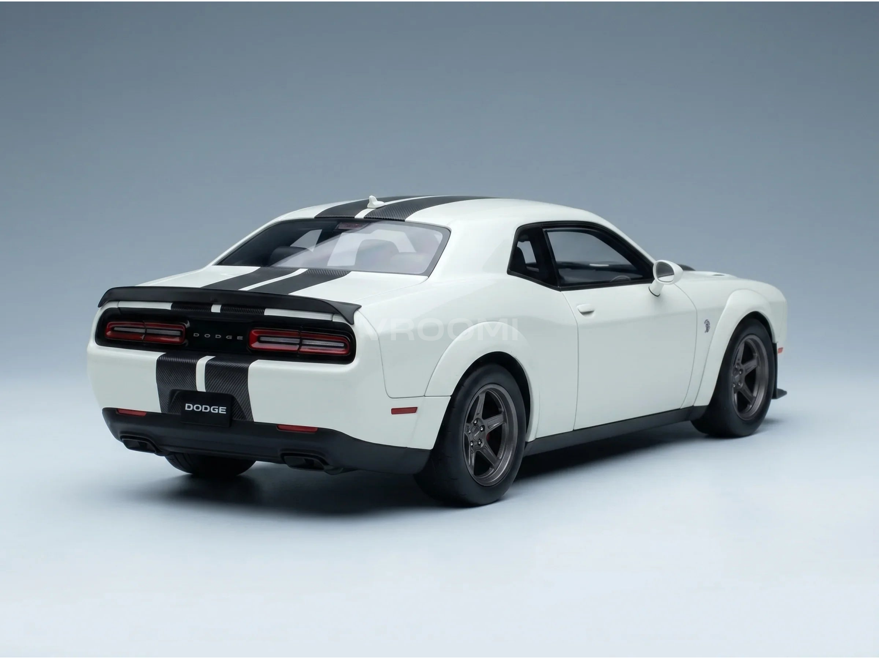 Maqueta a escala de un Dodge Challenger blanco con franjas de competición negras, presentada por Vroomi para coleccionistas.