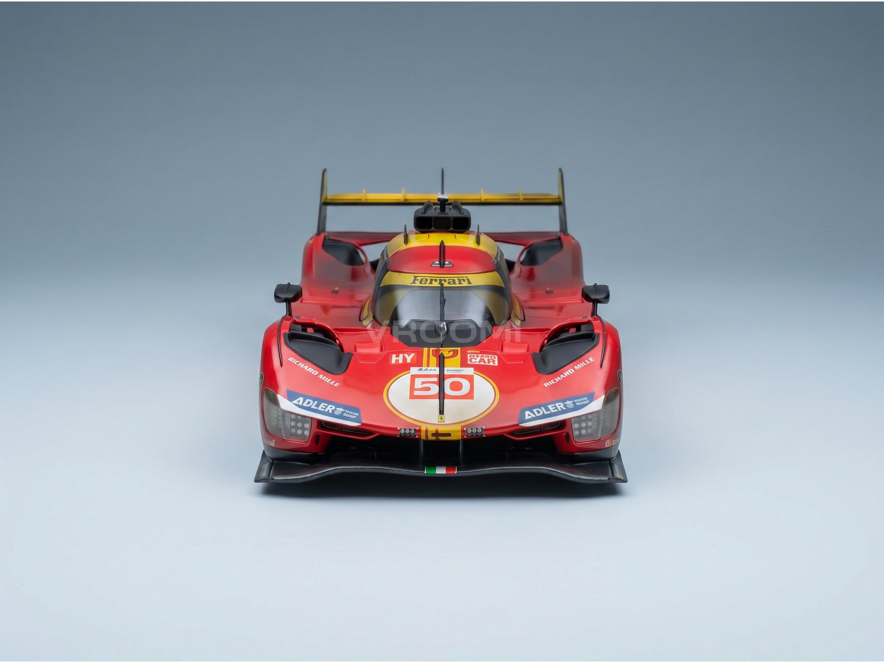 Rood Ferrari-modelauto op schaal 1:50 met race-stickers, gepresenteerd door Vroomi voor verzamelaars en motorsportliefhebbers.