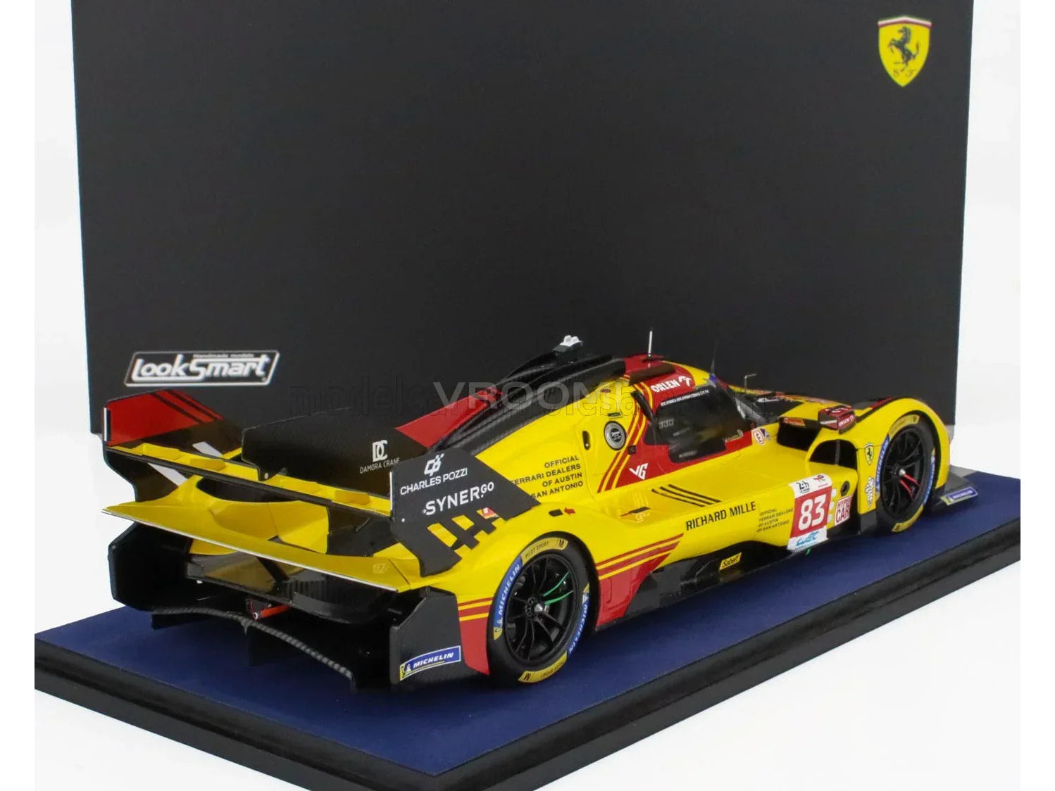 Maqueta a escala de un Ferrari 83 de carreras amarillo, de LookSmart, expuesta sobre una base azul — Vroomi
