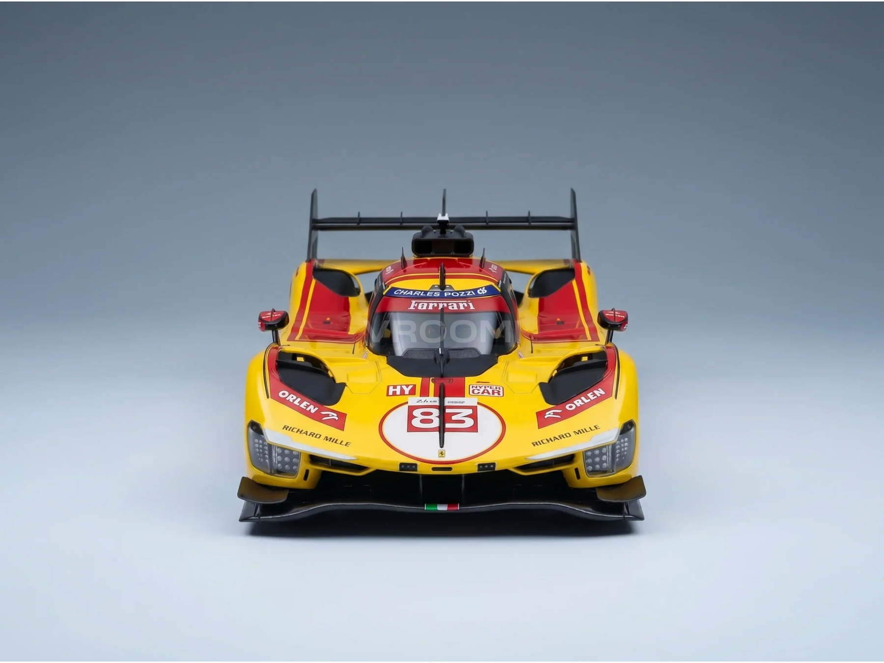 Maquette de voiture Ferrari jaune à l'échelle 1/83, arborant les logos Orlen et Richard Mille, présentée par Vroomi