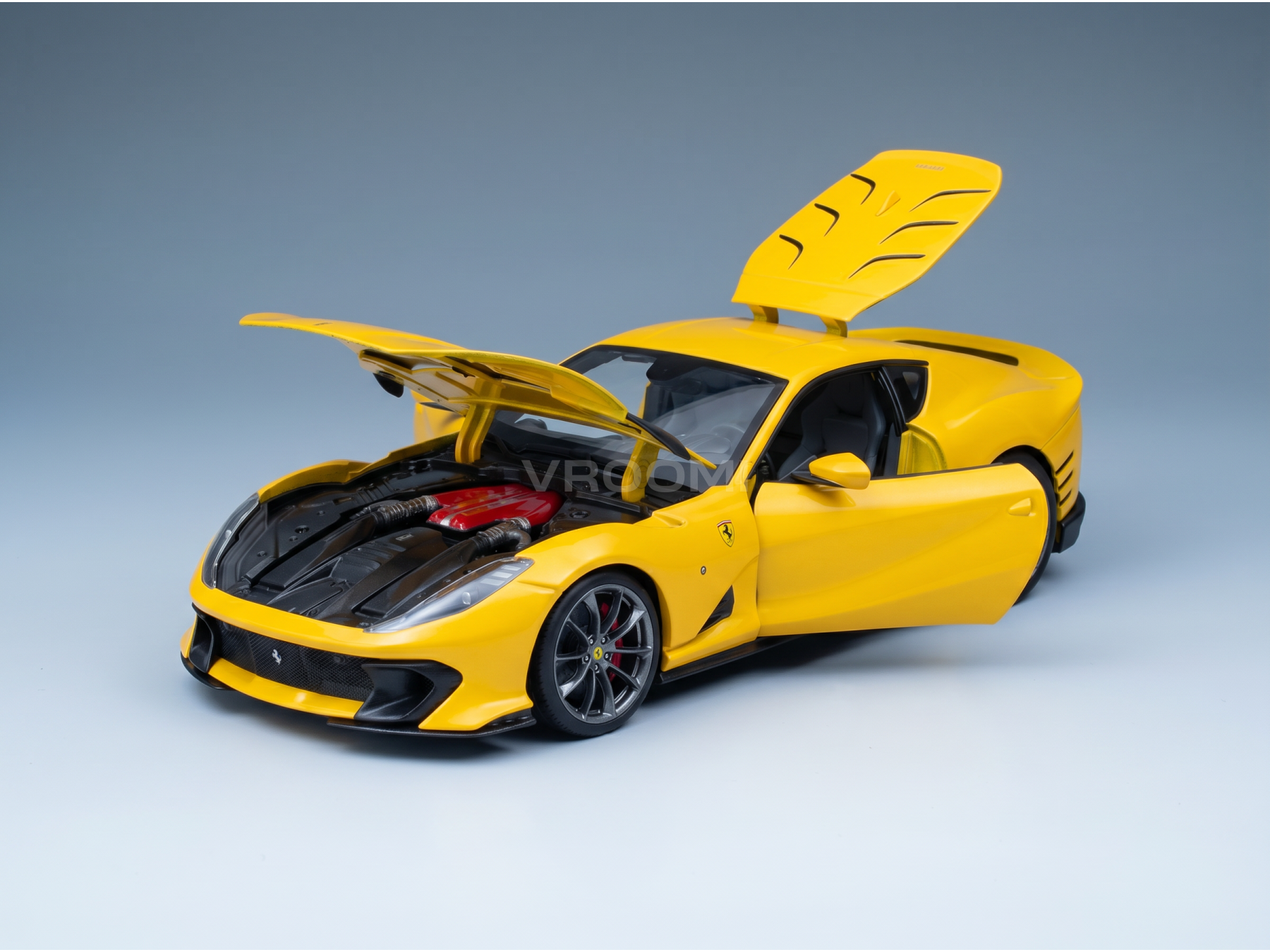 Maquette de Ferrari jaune avec les portes et le capot ouverts, présentée par Vroomi pour les collectionneurs.