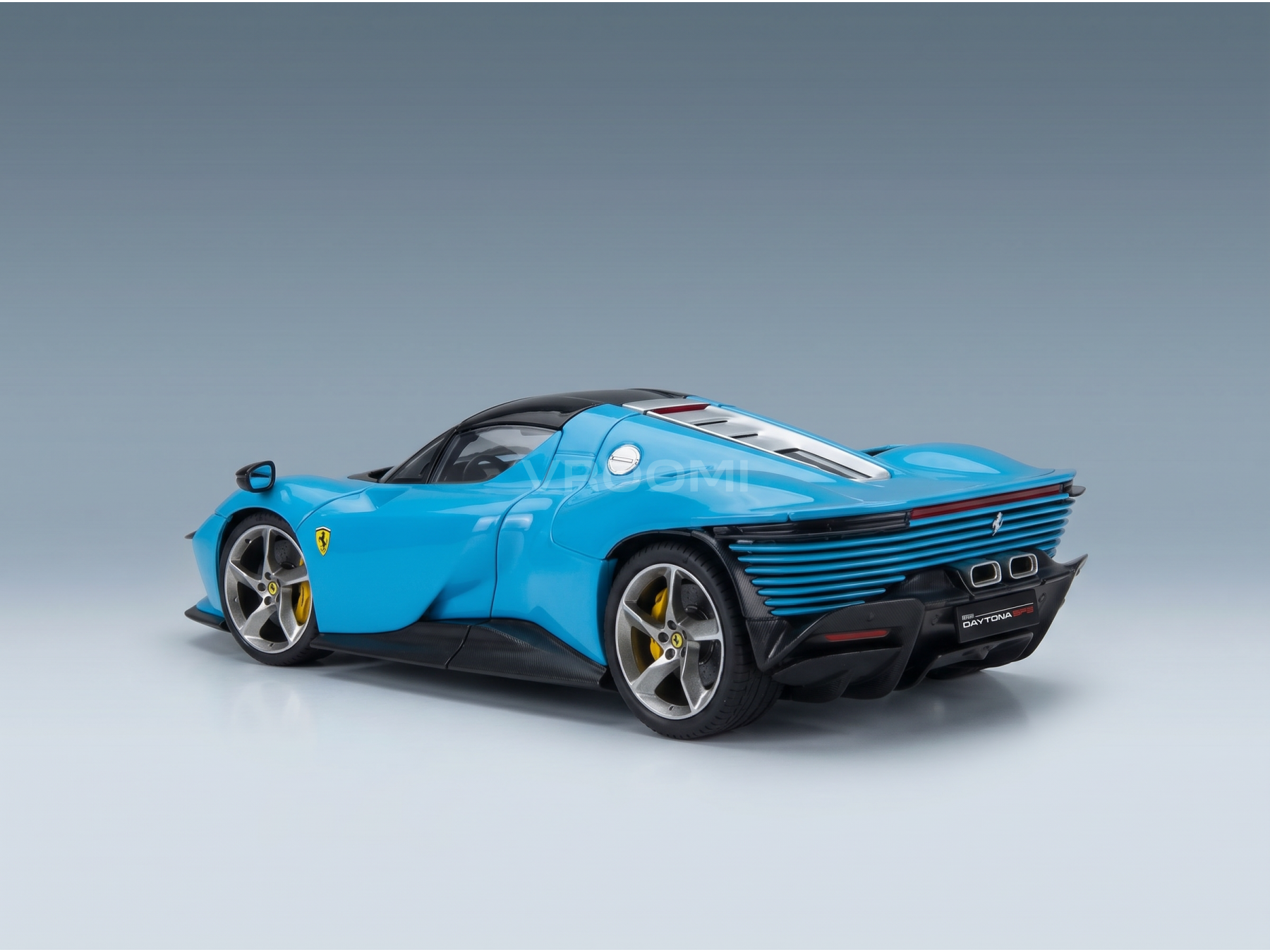 Maquette de la Ferrari Daytona SP3 bleue de la marque Vroomi, qui se distingue par son design épuré et sa calandre arrière très détaillée.