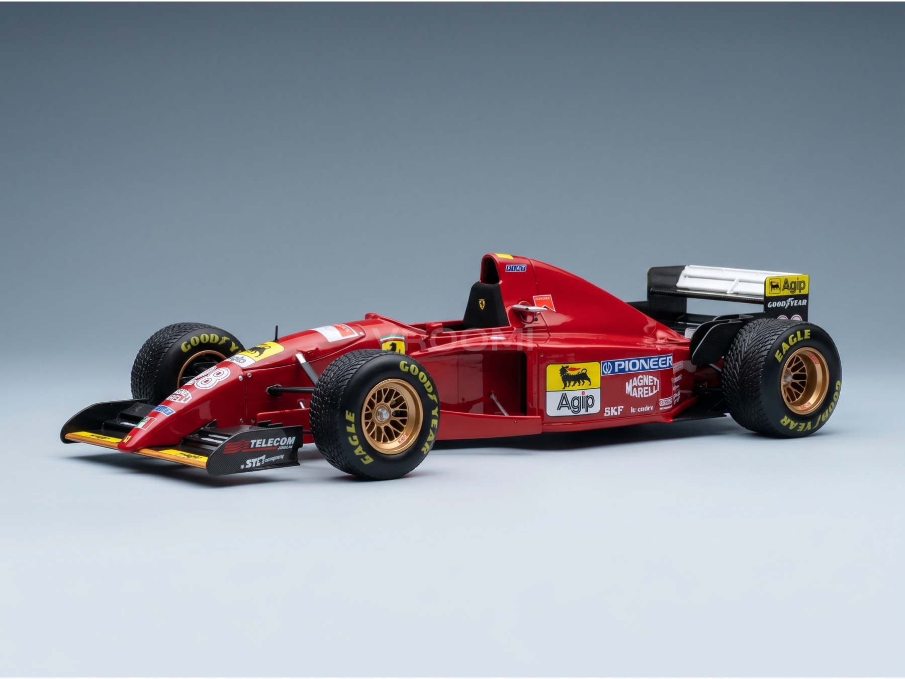 Red Ferrari scale model car with Goodyear tires, Agip, and Pioneer logos, showcased by Vroomi