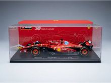 Maqueta a escala de un Ferrari F1 rojo de Charles Leclerc, n.º 16, expuesta en una vitrina transparente — Vroomi