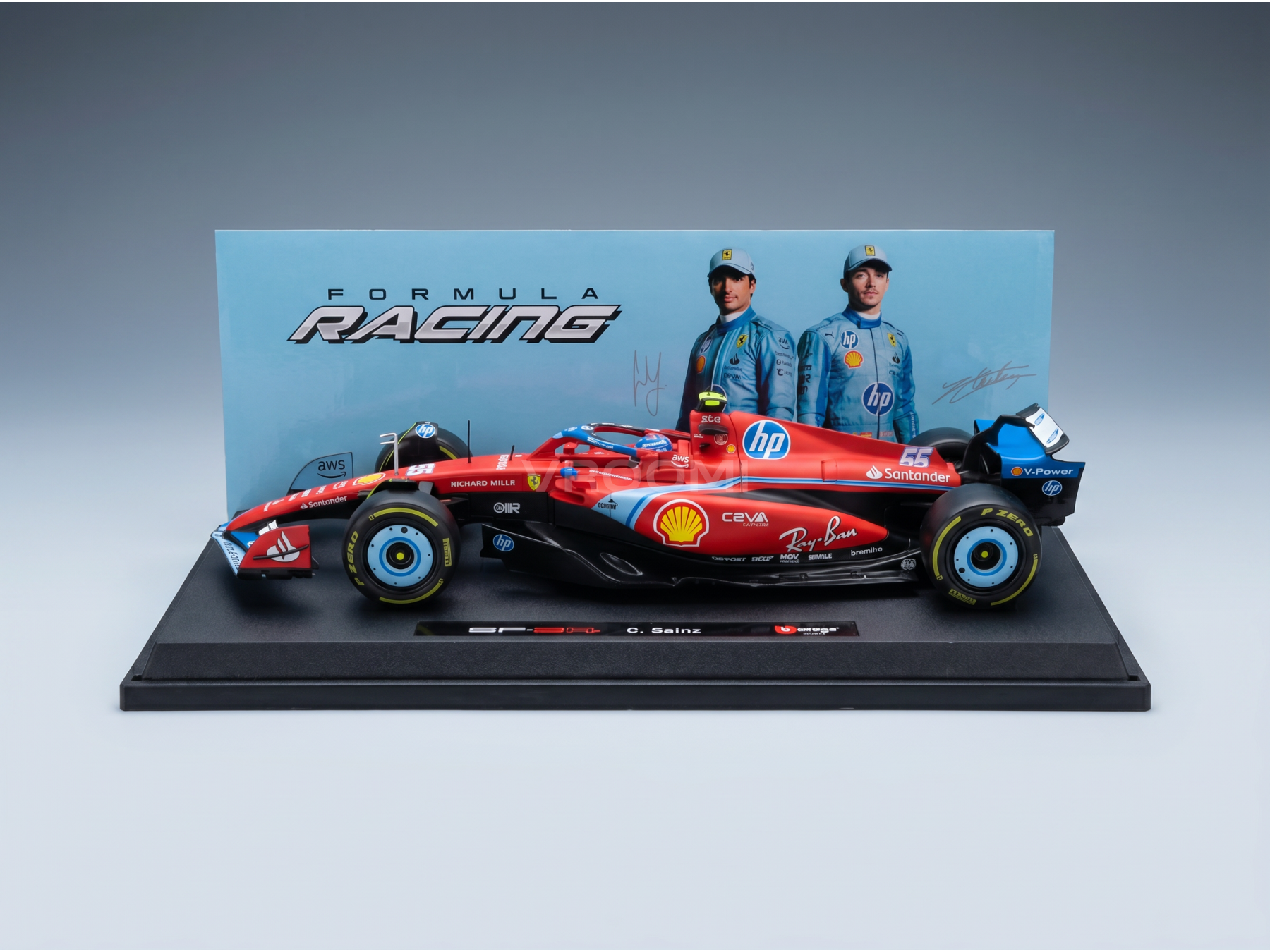 Maqueta a escala de un Ferrari rojo de Fórmula 1 de la marca Vroomi, con los logotipos de los patrocinadores y los nombres de los pilotos detallados en la base de exposición.