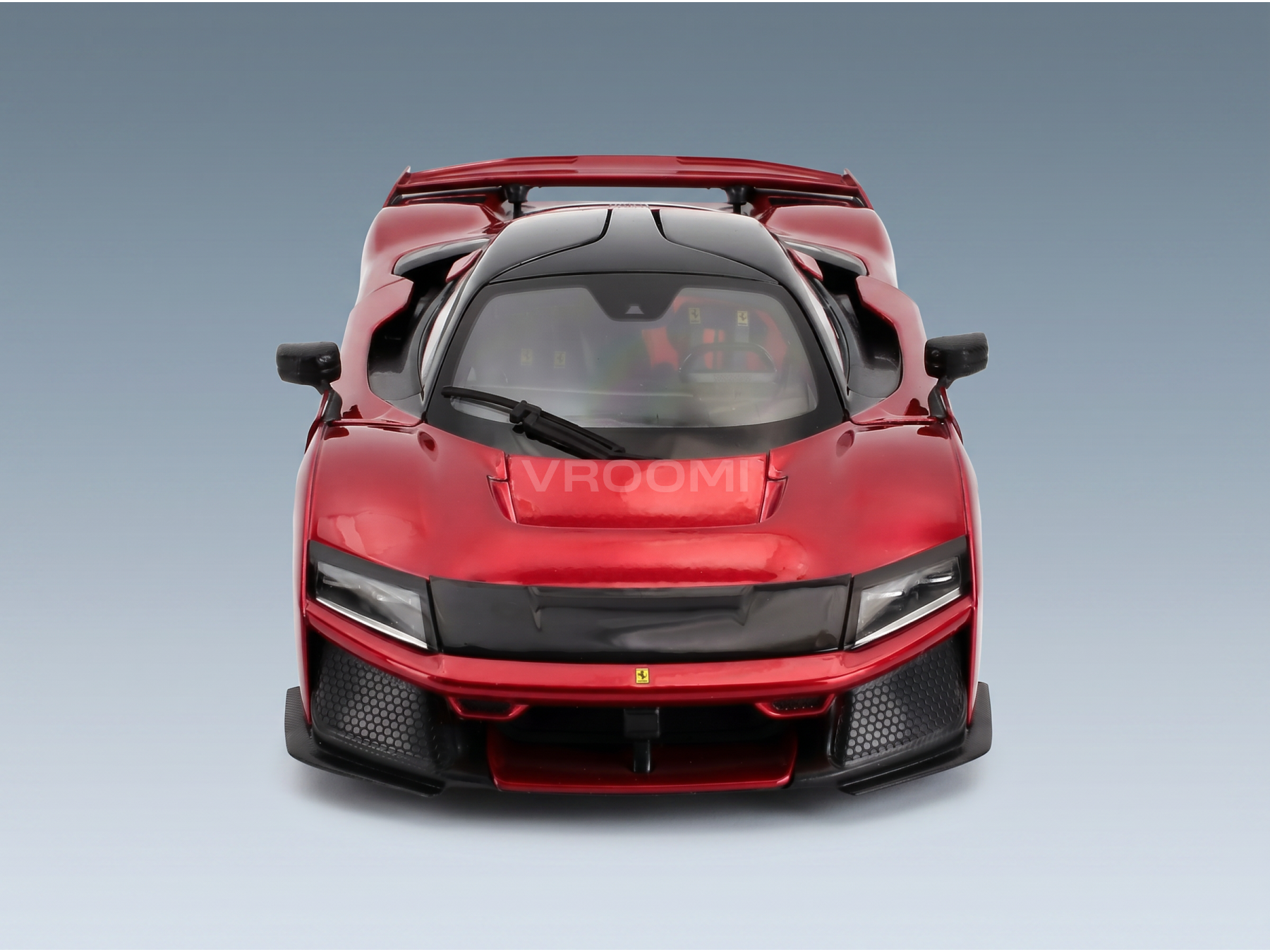 Rood Ferrari-schaalmodel met Vroomi-logo, met een gedetailleerde grille en een aerodynamisch ontwerp