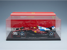 Maqueta a escala del Ferrari SF-25 en vitrina, con la marca Vroomi y los logotipos de los patrocinadores, ideal para coleccionistas.