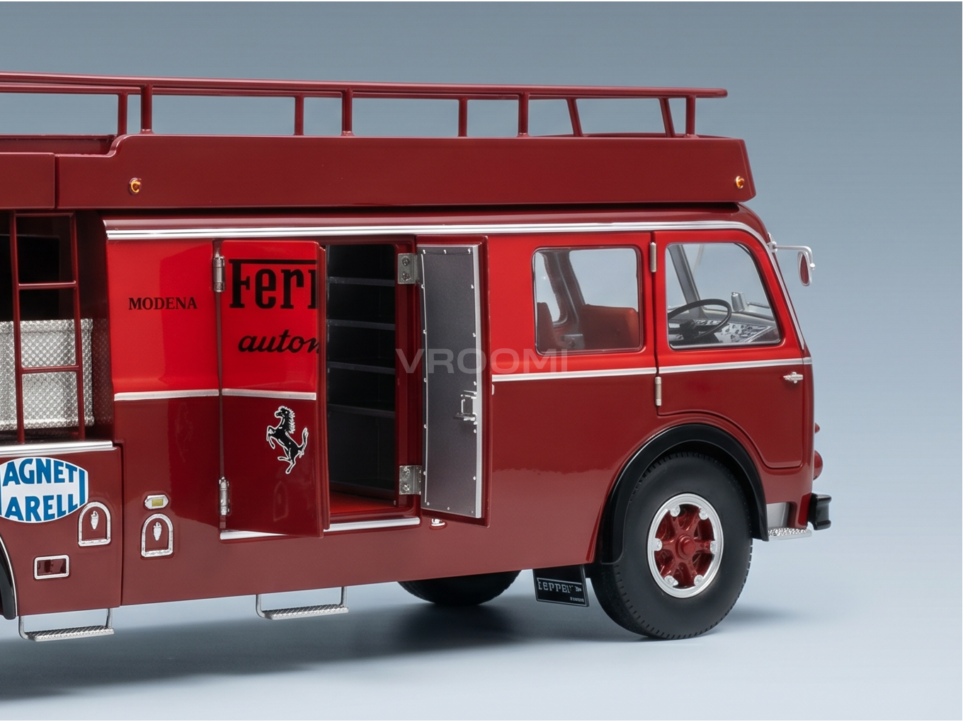 Modèle réduit de camion de transport Ferrari rouge de la marque Vroomi, avec des portes qui s'ouvrent et le logo « Modena »