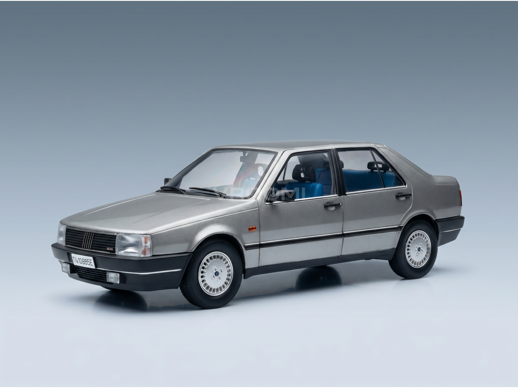 Silver scale model car with blue interior, showcased by Vroomi for collectors.
