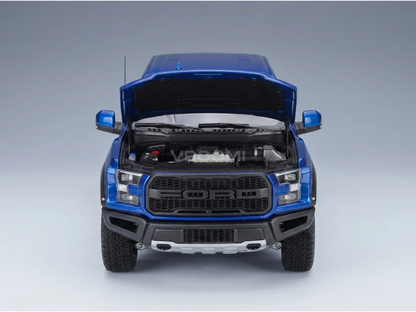 Maqueta a escala de un Ford Raptor azul con el capó abierto y motor detallado, de Vroomi