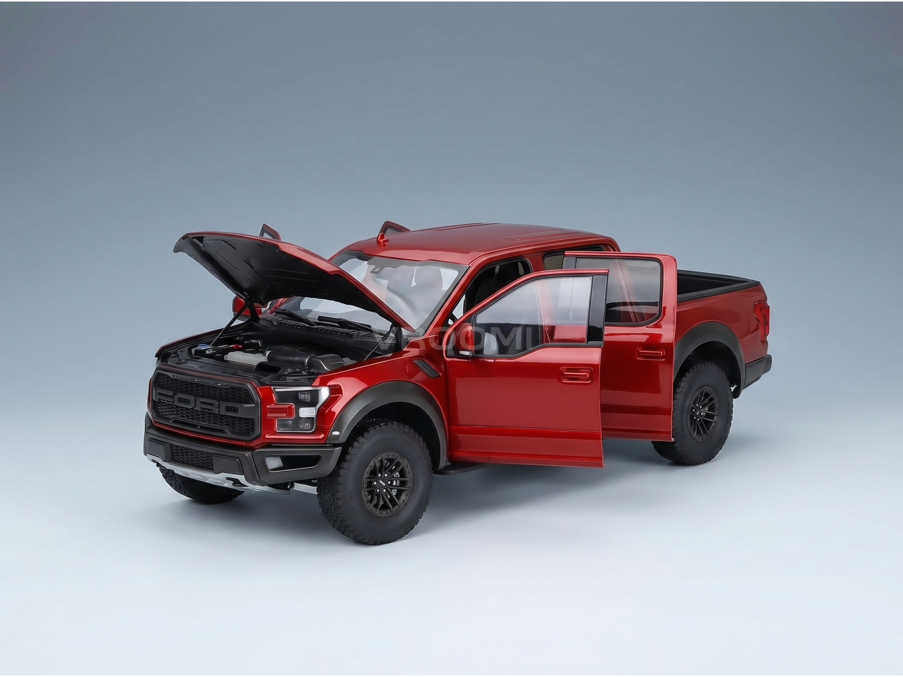 Maqueta a escala de un Ford Raptor rojo con el capó y las puertas abiertos, presentada por Vroomi para coleccionistas.