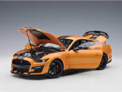 Orange scale model car with open hood and trunk, showcased by Vroomi for collectors.