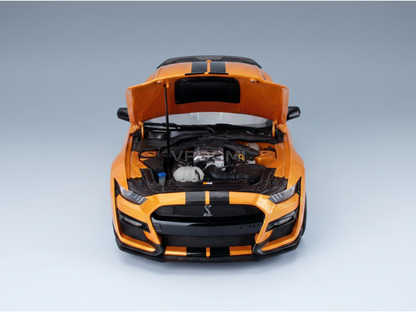 Orange scale model car with open hood, detailed engine, and black stripes, available at Vroomi