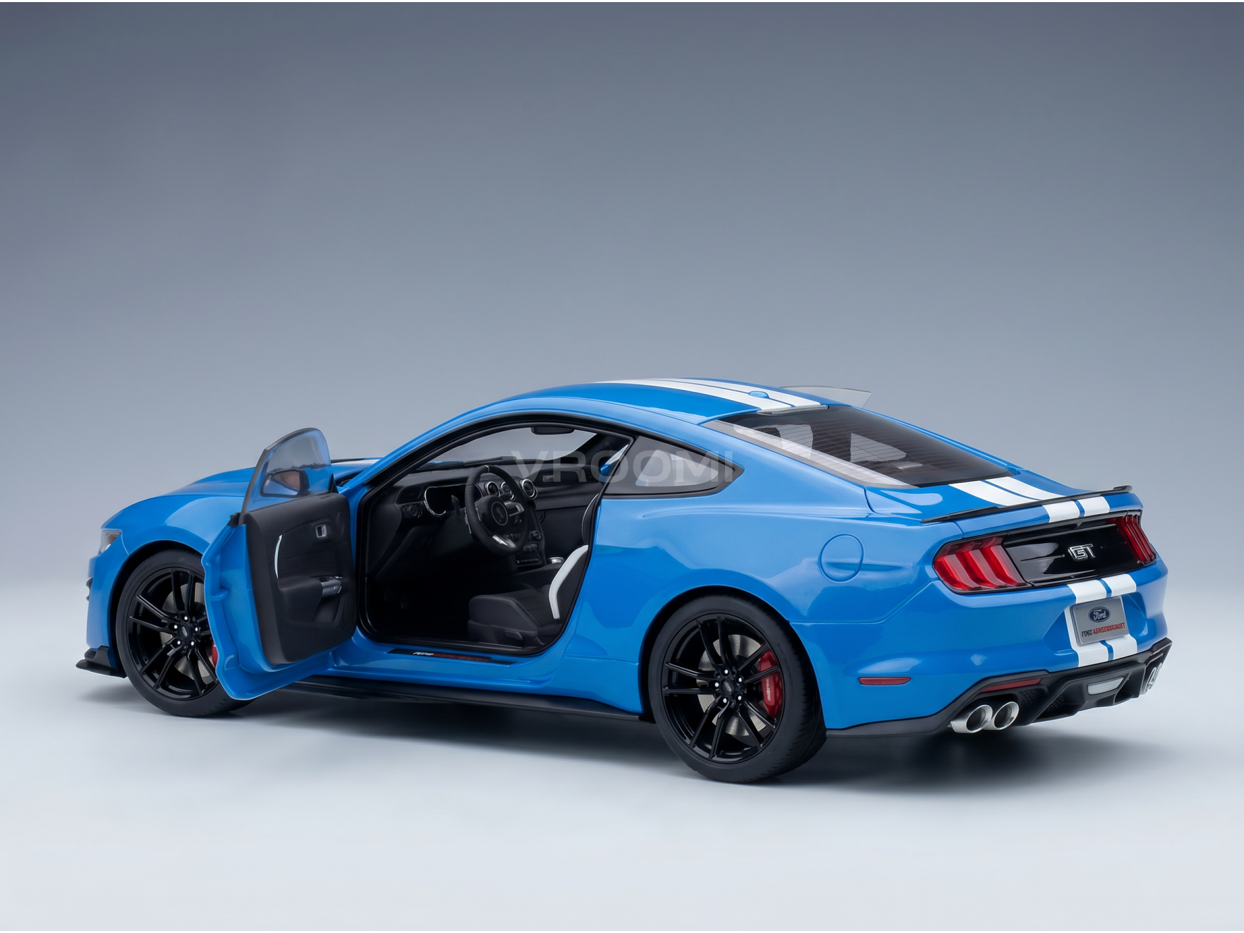 Maqueta a escala de un Ford Mustang GT azul con la puerta abierta, presentada por Vroomi para coleccionistas.