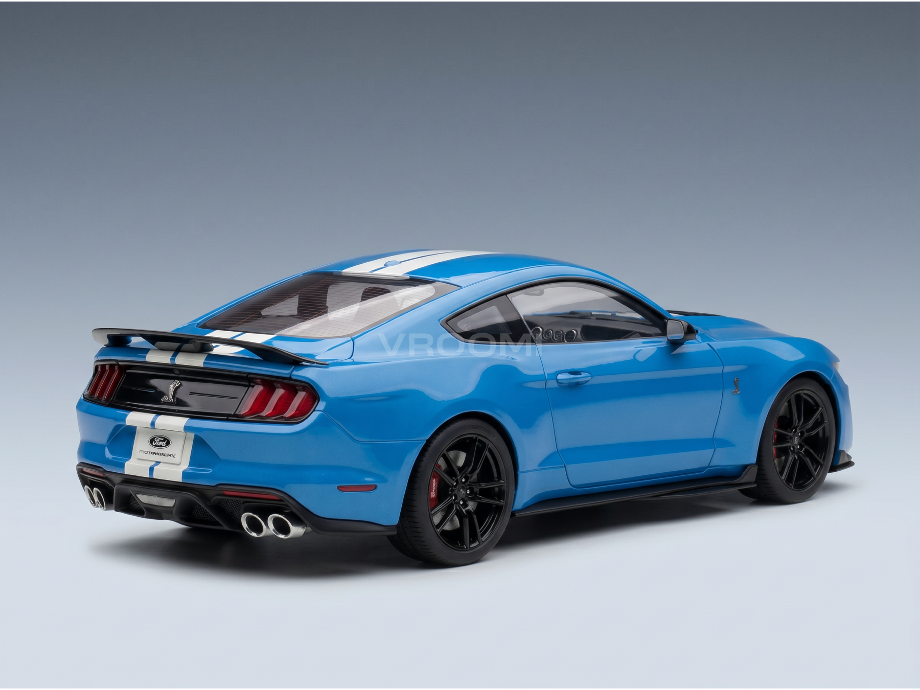 Maqueta de un Ford Mustang azul con rayas blancas, presentada por Vroomi para coleccionistas.