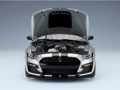 Maqueta a escala del Shelby GT500 plateado con el capó abierto, motor detallado y la marca de agua «Vroomi»