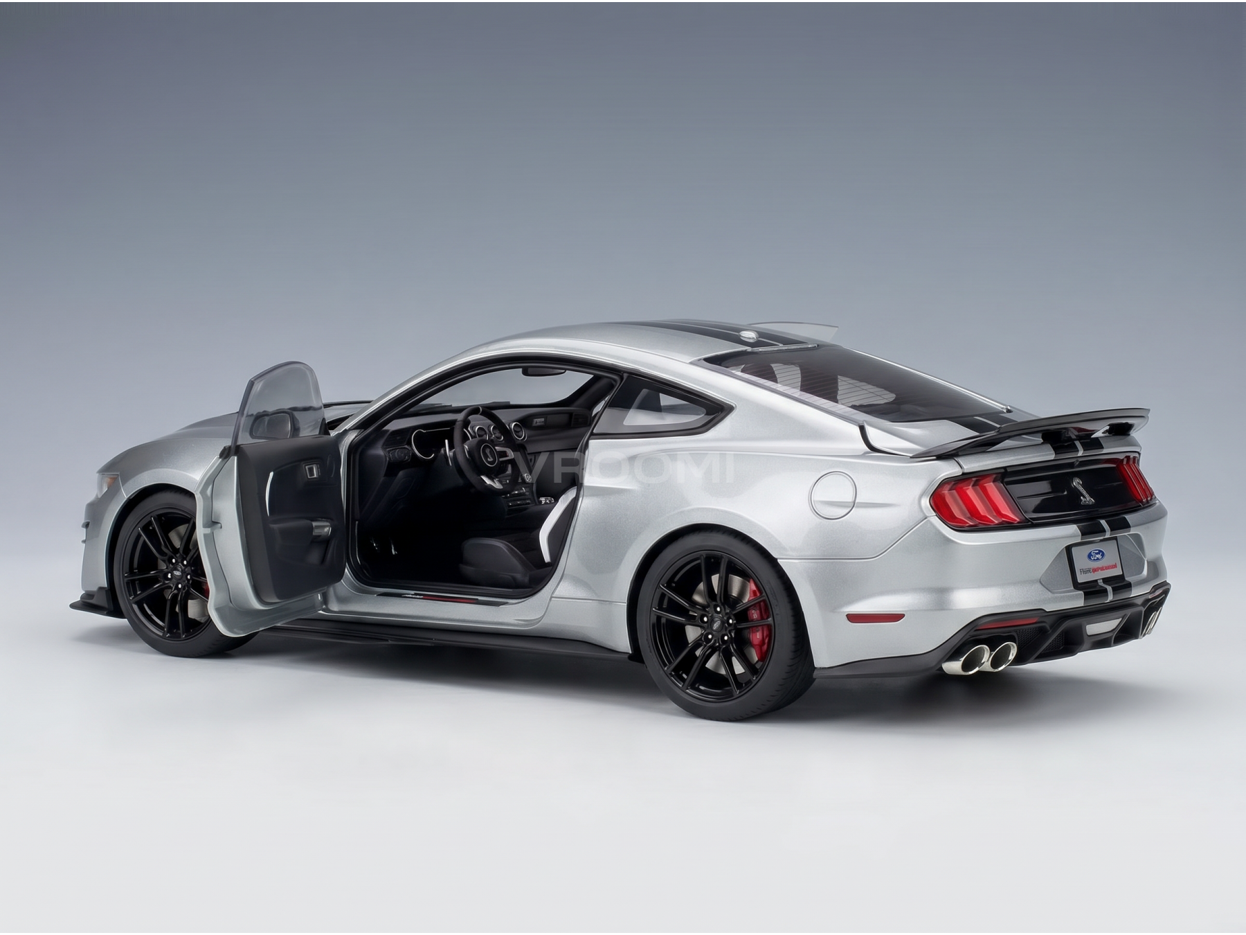 Maqueta a escala de un Ford Mustang Shelby GT500 plateado, con la puerta abierta e interior detallado, en Vroomi