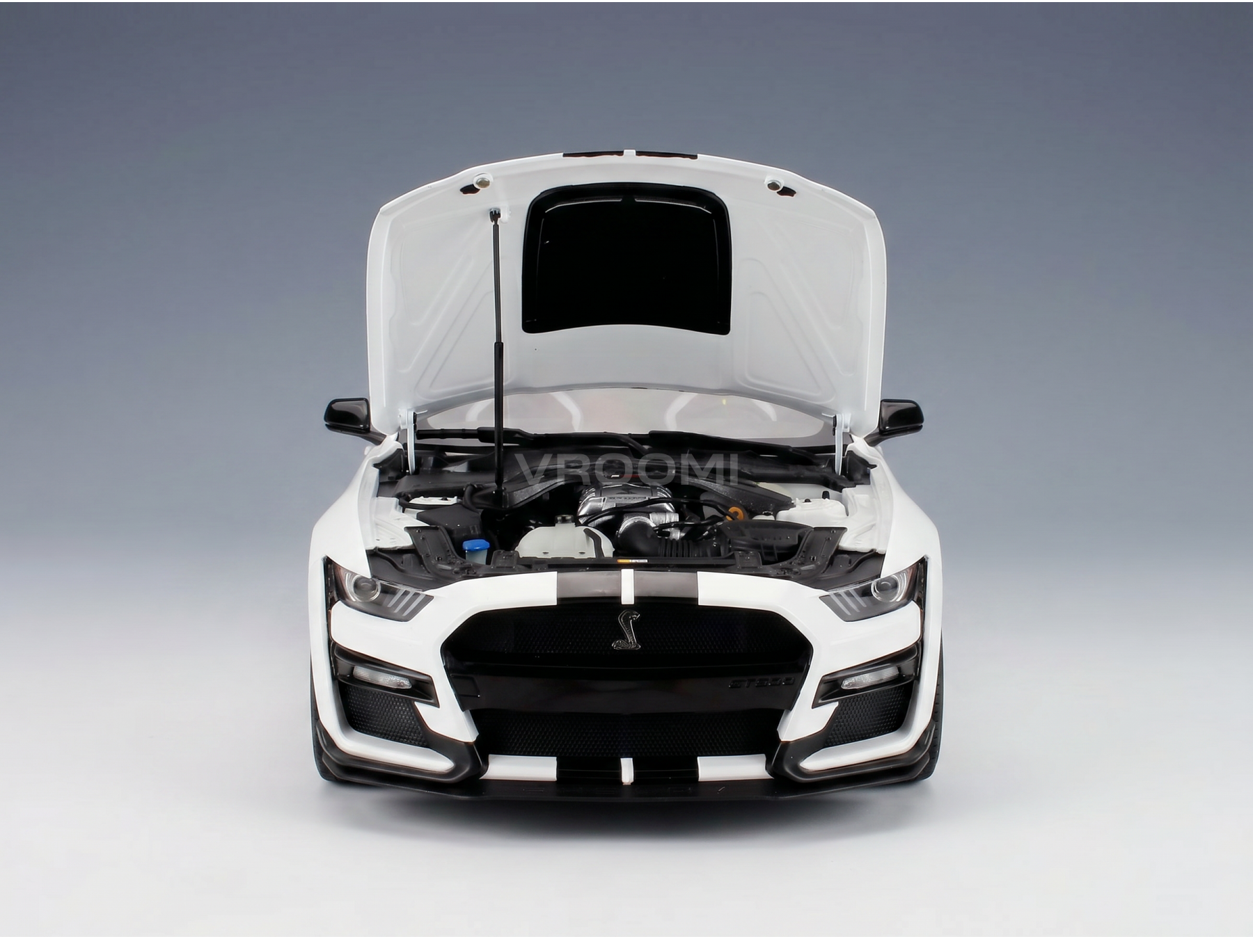 White Shelby GT500 scale model car with open hood, detailed engine, and Vroomi branding