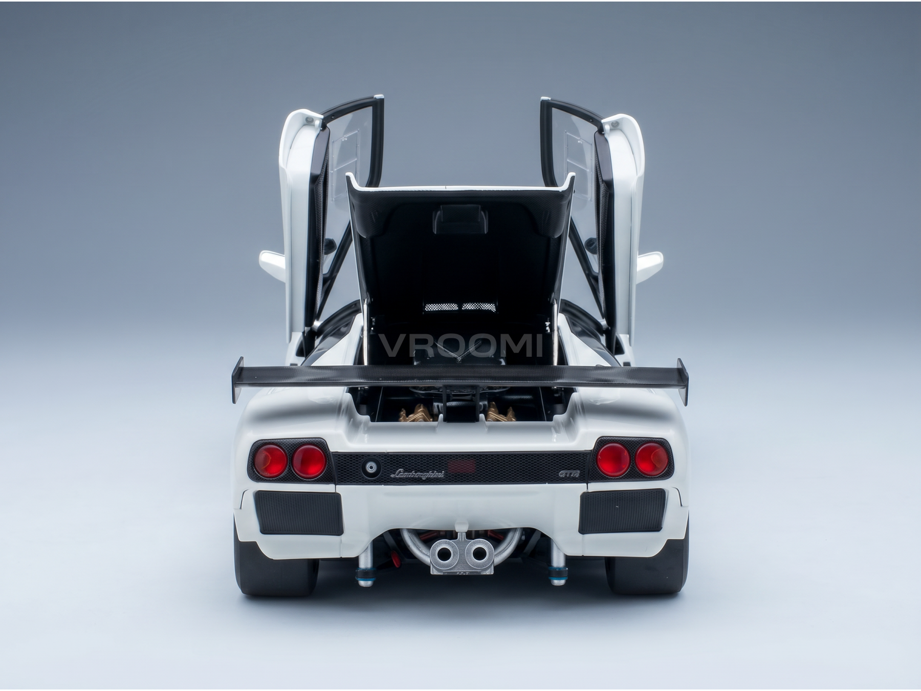 Maqueta a escala de un Lamborghini GT1 blanco con las puertas abiertas y el compartimento del motor trasero a la vista, presentada por Vroomi