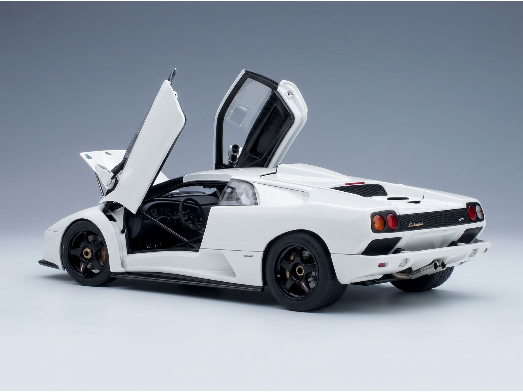 Maqueta de coche Lamborghini blanca con las puertas abiertas, presentada por Vroomi para coleccionistas.